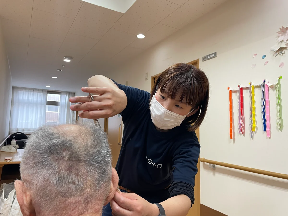 出張の訪問理美容でデイサービスの利用者の散髪を行う福祉美容師