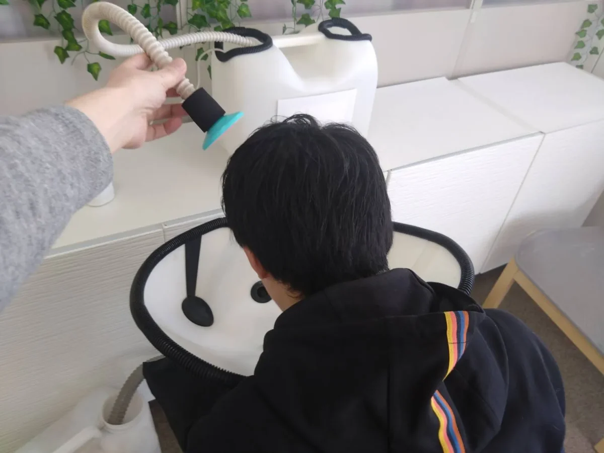 移動式シャンプー台で前流しで洗髪する様子