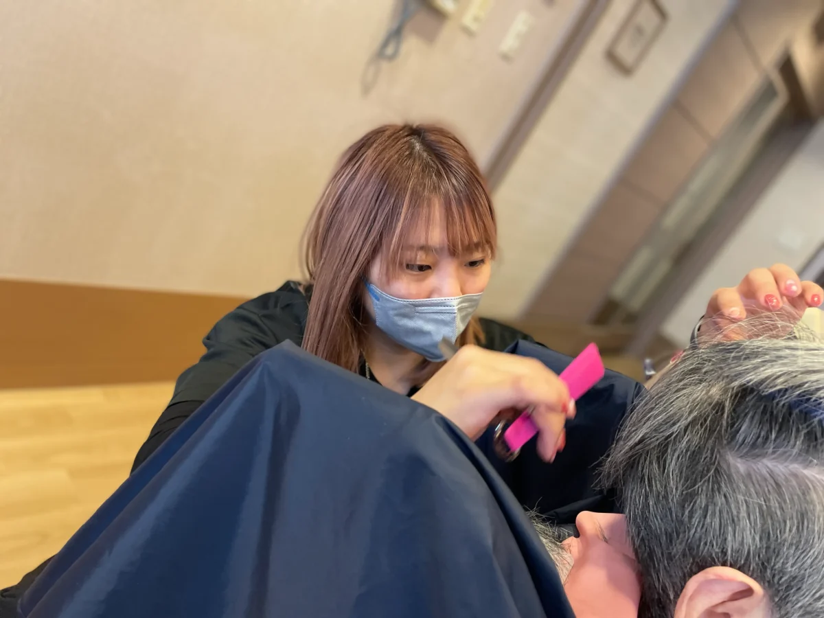 訪問美容でヘアカットする女性の美容師
