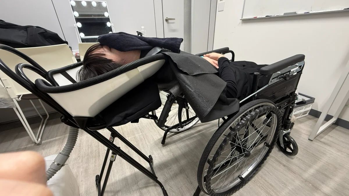 移動式シャンプー台で車いすのまま仰向けでシャンプーする様子