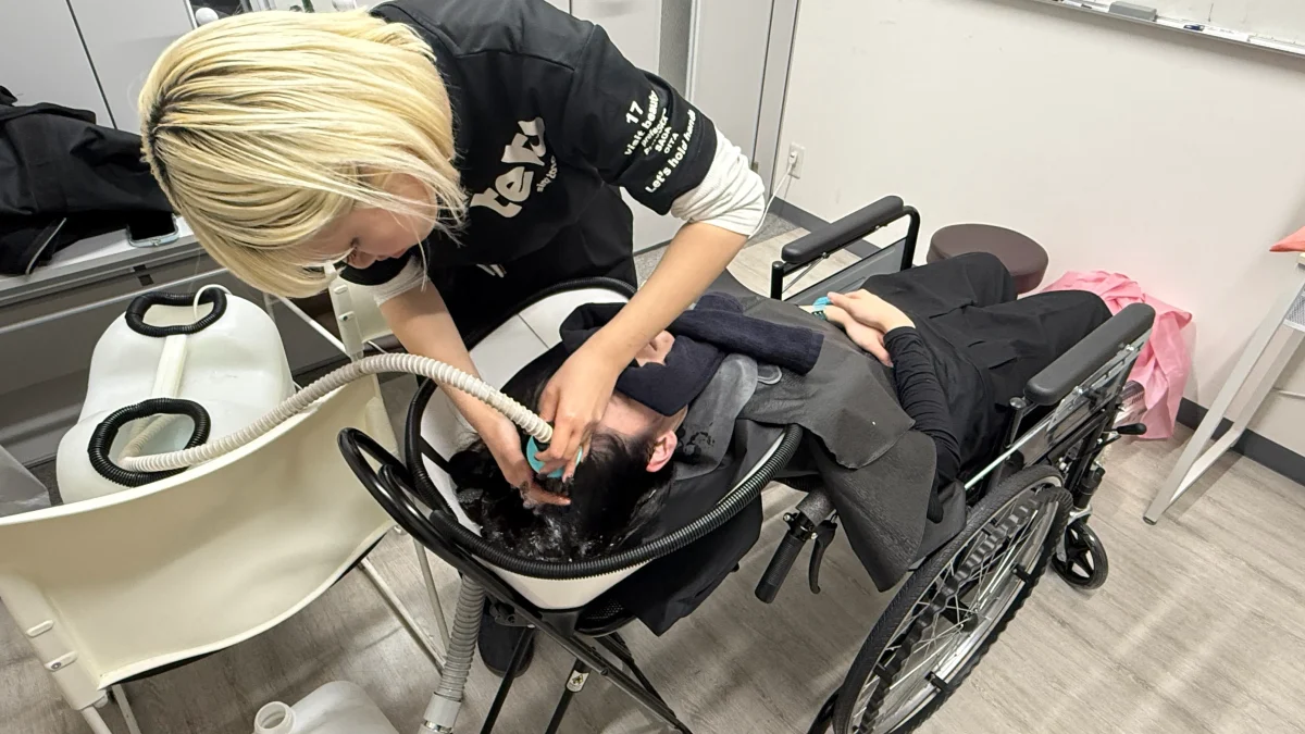 移動式シャンプー台で車いすのまま仰向けでシャンプーする様子