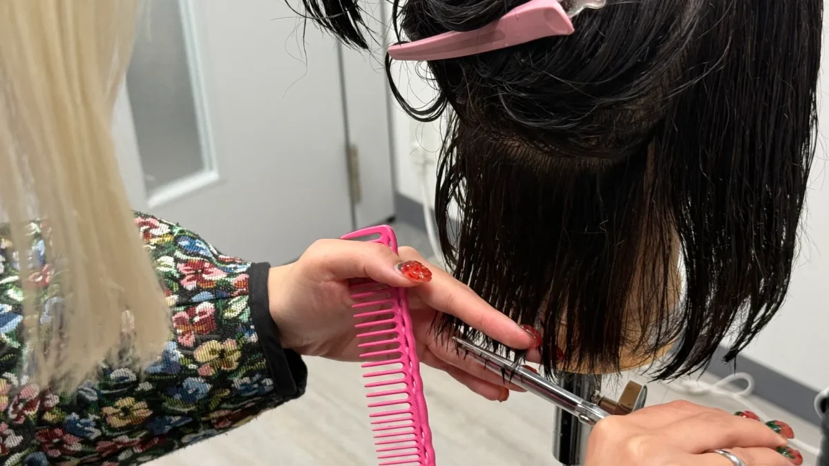 ワンレングスカットを練習する女性美容師