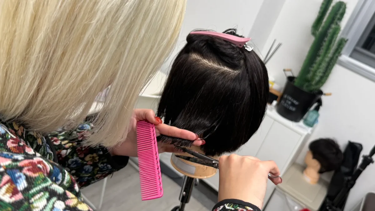 グラデーションカットの練習をする女性美容師
